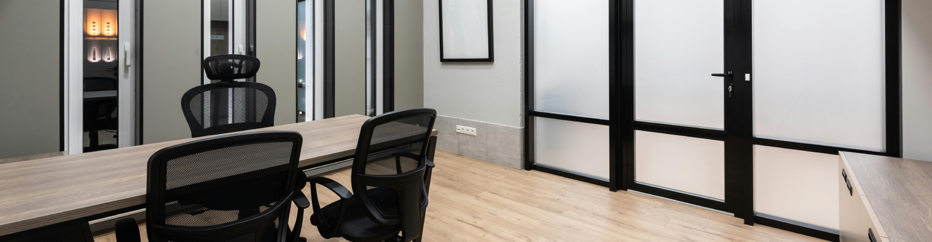 A conference room featuring black chairs arranged around a central desk.